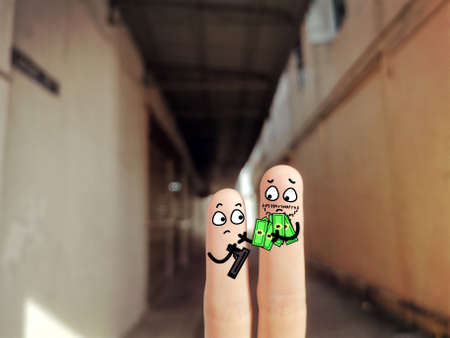 Two fingers are decorated as two person. They are at the back yard. They are doing illegal business.の写真素材