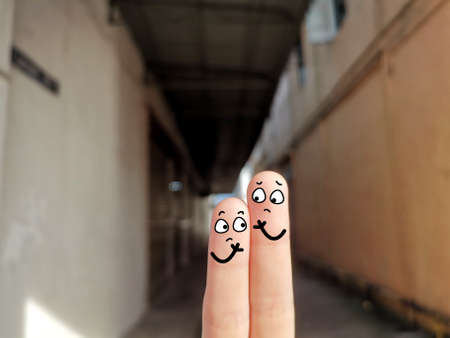 Two fingers are decorated as two person. They are at the back yard. They are worried.の写真素材