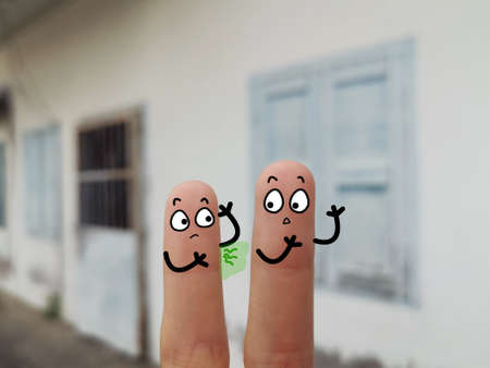 Two fingers are decorated as two person. They are at the back yard. One of them is having bad body odour.の写真素材