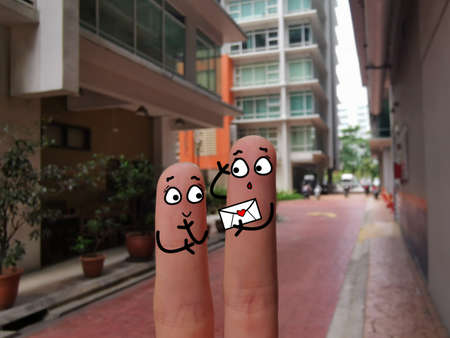 Two fingers are decorated as two person. A girl sends a love letter to a boy.の写真素材