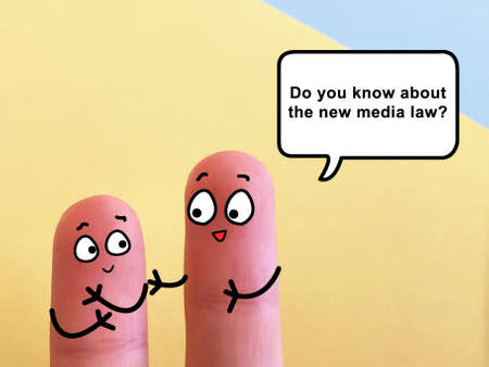 Two fingers are decorated as two person. They are discussing about the new media law.の写真素材