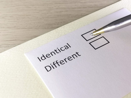One person is answering question on a piece of paper. The person is thinking to be identical or...