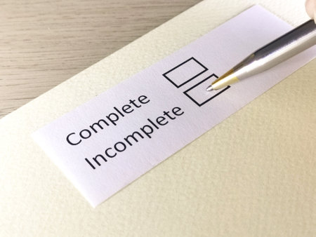 One person is answering question on a piece of paper. The person is thinking to be complete or incomplete.の写真素材