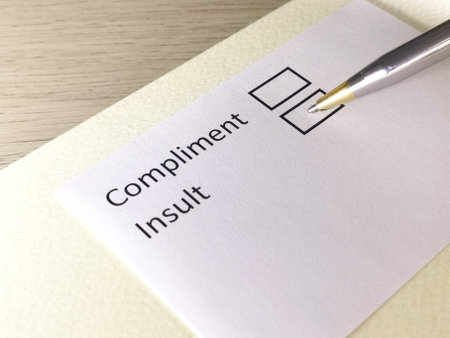 One person is answering question on a piece of paper. The person is thinking to give compliment or insult.の写真素材