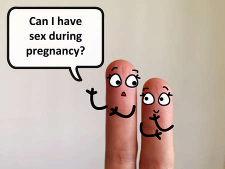 Two fingers are decorated as two girls. One of them is asking if she can have sex during pregnancy.の写真素材