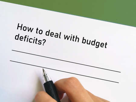 One person is answering question about banking. He is thinking how to deal with budget deficits.の写真素材