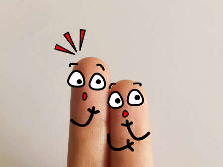 Two fingers are decorated as two person. Both of them are in shocked.の写真素材