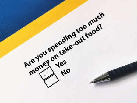 One person is answering question. He thinks that he is spending too much on take out food.の写真素材