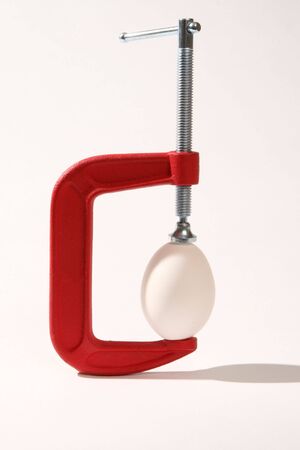 Fragile egg being squeezed in a C clampの写真素材