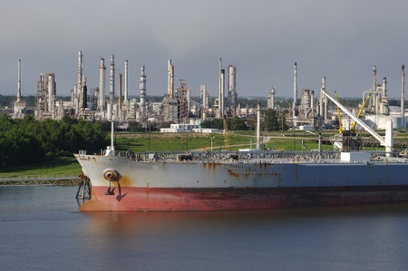 Oil refinery on the mississippi river near the gulf entrance with tanker ship in the foregroundの写真素材
