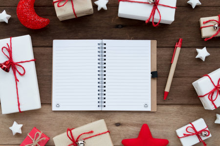 Blank Notebook and gift boxes on wooden backgroundの写真素材