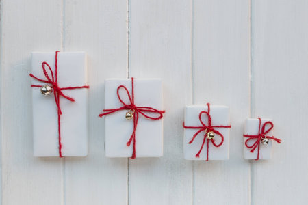 Handmade white gift boxes on white wood background
