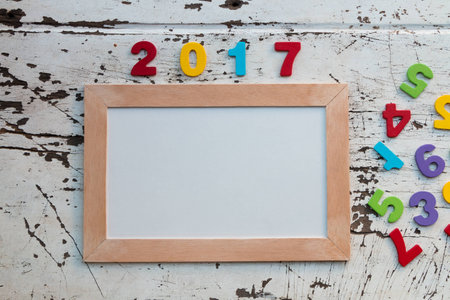 "2017"  Letter and blackboard on wood background.  Flat laying in top viewの写真素材
