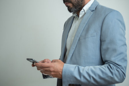 Businessman in casual suit checking his smartphoneの写真素材