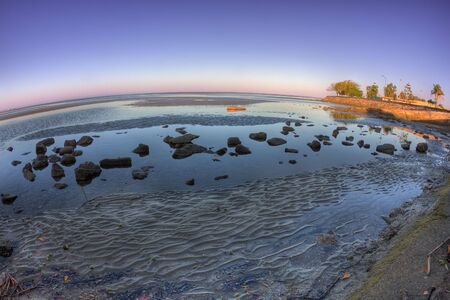 View of Sandgate mudflats during low tide. High Dynamic Range (HDR) image taken with a fisheye lens, hence the strong curvature of the horizon. の写真素材