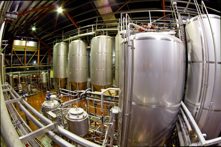 View of the machinery and vats inside a brewery. Image captured with a fisheye lens