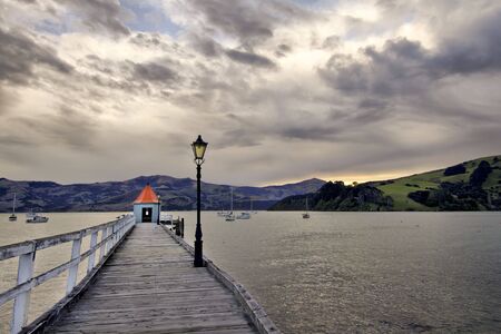 View of a pier and hut at Akaroa, New Zealand.の写真素材