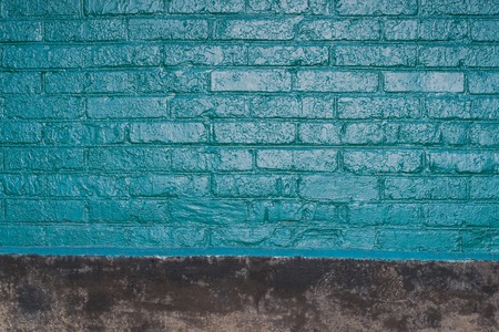Vintage texture of old brick wall dyed in turquoise color. Painted facade of apartment houseの写真素材
