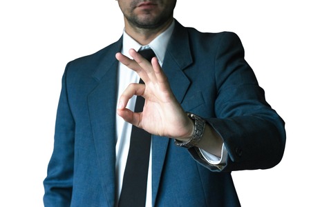 Young businessman in jacket and white shirt shows gesture ok. Business concept, focus on handの写真素材
