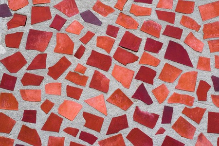 The texture of mosaic wall decorative ornament from ceramic broken tile in orange color, like Gaudi. Can be used as a background in interior design. Exterior of the facade of the house.の写真素材