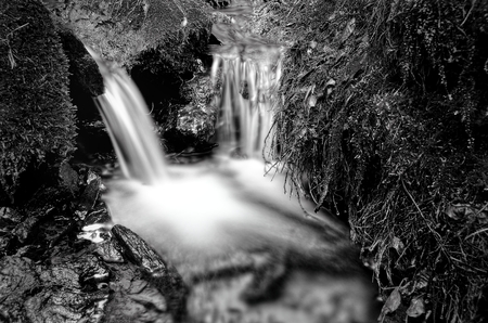 Detail of small waterfall on mossy rock.の写真素材