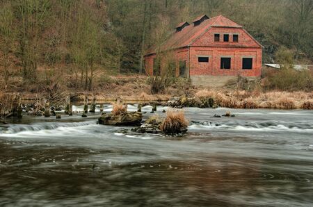 An old house near by old demolished weir od the riverの写真素材