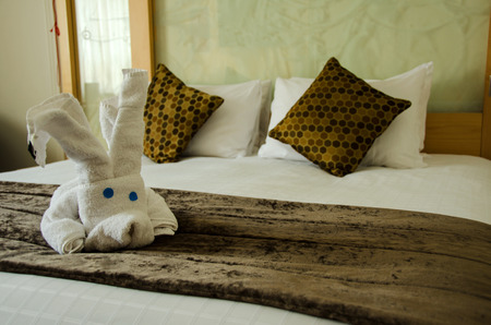 White brown bedroom with white plush toy on the brown bed cover.の写真素材