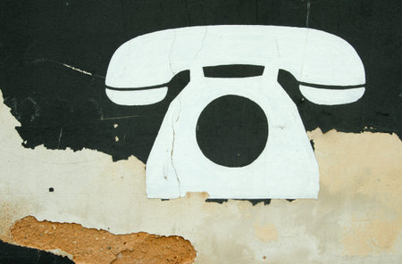 White symbol of big phone painted on old wall.の写真素材