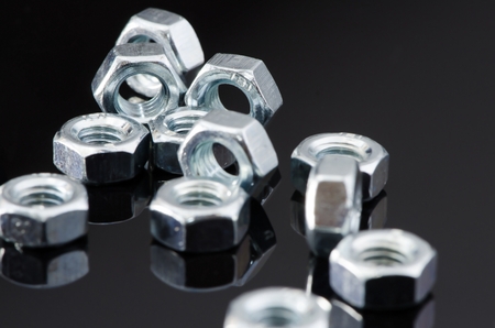 Several Metal female screws with reflection on black background.の写真素材
