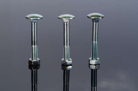 Three metal screw with nice reflection on black background.の写真素材