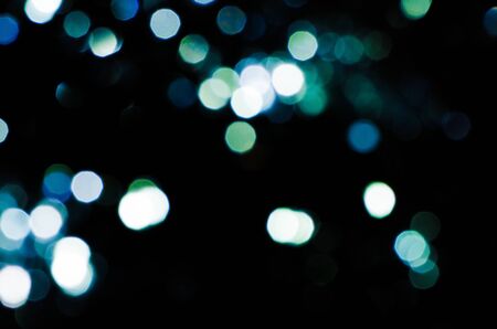 Black background with green and blue blur circles.の写真素材