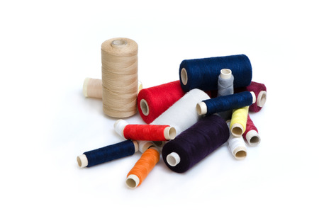 Heap of plenty colorful thread reels isolated on white background.の写真素材