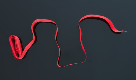 Curled red ribbon isolated on black background.の写真素材