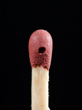 Detail of damaged red match head isolated on black backgroudn.の写真素材