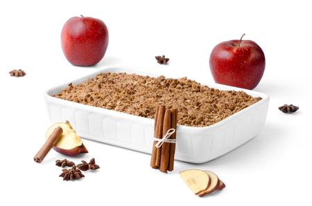 Christma still life consisting of red apples, cinammon and apple crumble against white background.の写真素材