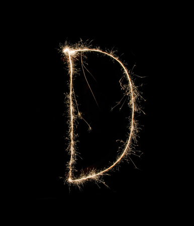 Letter D drew with spakrs on a black background.の写真素材