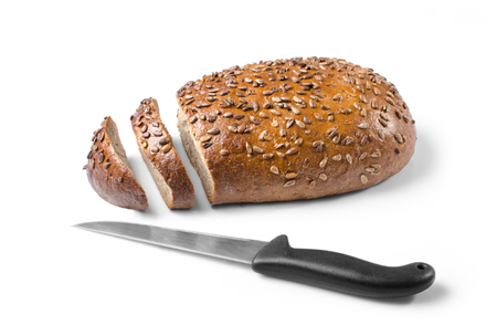 Cut loaf of wholemeal bread and knife isolated on white background as a healthy eating concept.の写真素材