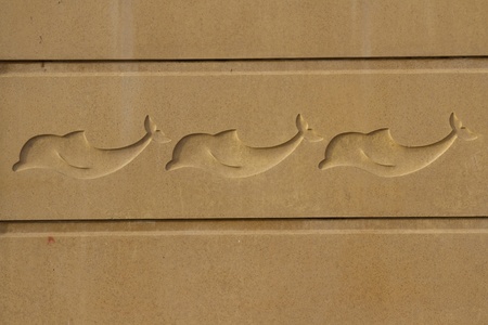 Sand coloured concrete cast panels with dolphin symbols in the centreの写真素材