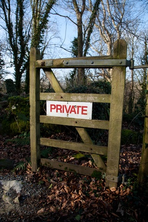 A wooden woodland gate with a white sign with the words 'PRIVATE' in red.の写真素材