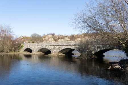 Old stone bridge over the river Seiont, Wales, on a sunny winter day in the countrysideの写真素材