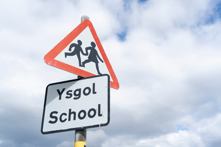 Warning signs for school children in English and Welsh on a roadside in Wales, UKの写真素材