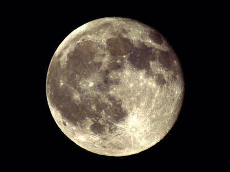 The cratered landscape of Earth's closest celestial neighbor is visible as the Full Moon has a luminous presence in the night sky.の写真素材