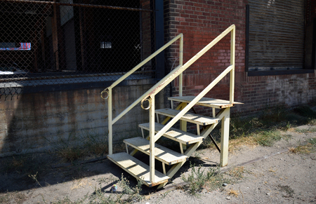 A metal staircase stands outside of an abandoned warehouse building in Los Angeles.の写真素材