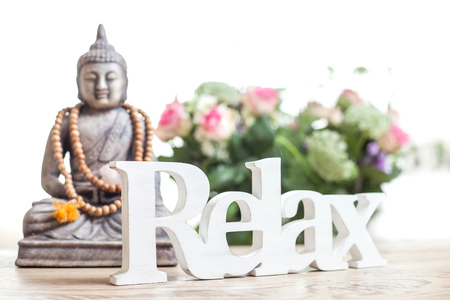 Buddha statue with beads. Buddha statue and the word relax in wood lettering.の写真素材