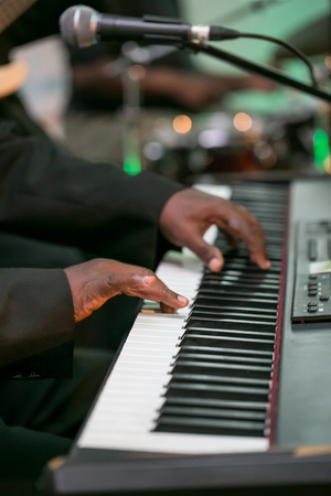 Hands playing the keyboard of a piano.の写真素材