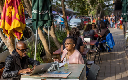 Johannesburg, South Africa, April 29-2018: Couple sitting at street cafe working on laptop.のeditorial素材