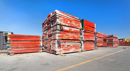 Scaffolding poles and brackets stacked in a yard.のeditorial素材