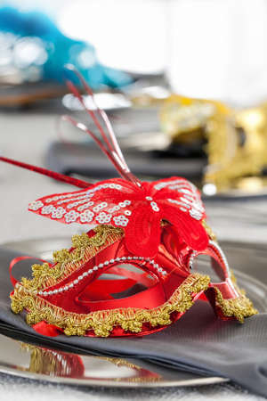 Table decorations with face masks at night time event with candles in background.の写真素材