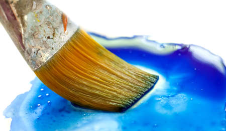 Paint brush dipping into paint.の写真素材