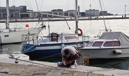 a young man is fishing on a seashoreの写真素材